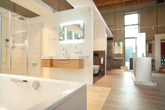 Moderne Badezimmeransicht mit Badewanne, Dusche, Waschbecken und großen Fenstern.